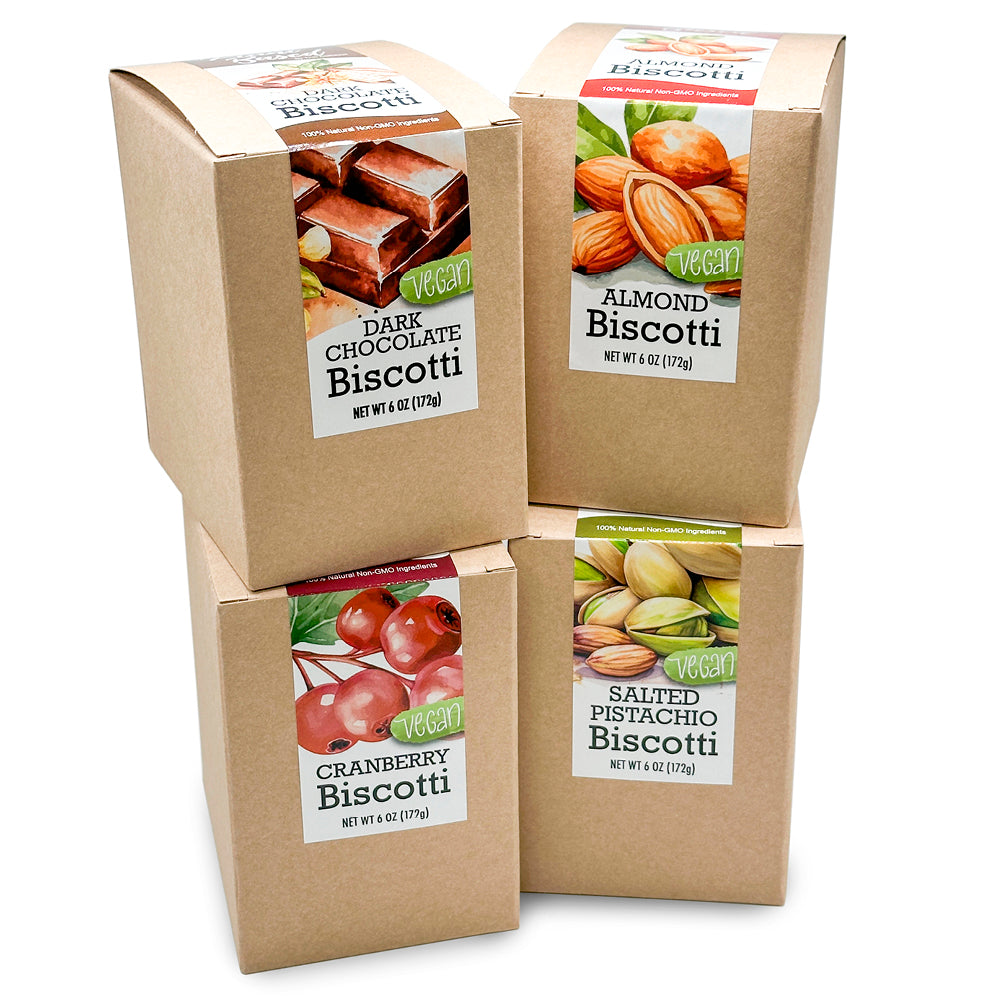 Four boxes of True Delicious Plant-Based Biscotti Collection are stacked together, each featuring a different flavor—dark chocolate, almond, cranberry, and salted pistachio—with images of the ingredients on their labels.
