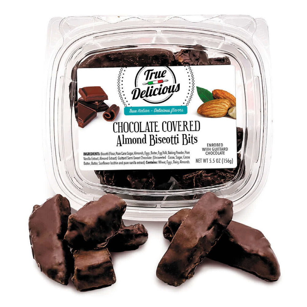 An open container labeled True Delicious Chocolate Covered Almond Biscotti Bites sits with chocolate-coated pieces in front. The label shows almonds and chocolate and notes Non-GMO ingredients and Guittard Semi-sweet Chocolate.